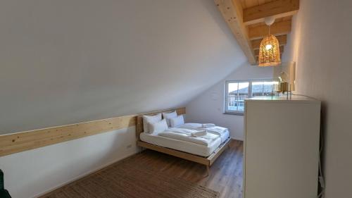 Habitación pequeña con cama y ventana en LIBORIA I Traumhafte Ferienwohnung in Aidling am Riegsee mit atemberaubendem Blick auf die majestätische Zugspitze! en Riegsee