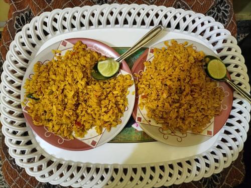 dois pratos de arroz numa mesa com colheres em Red king home stay em Bikaner