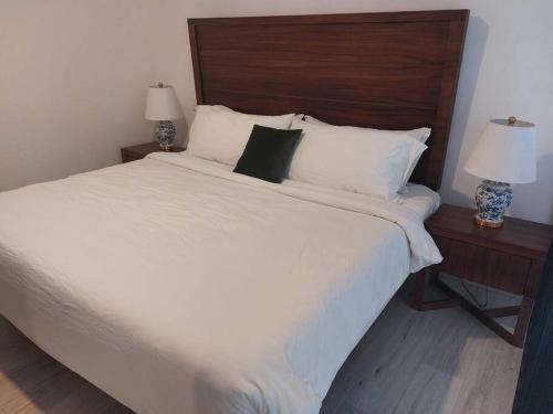 ein Schlafzimmer mit einem großen weißen Bett mit zwei Lampen in der Unterkunft Casa Monarcas - Eleonor (with AC) in Guadalajara