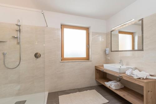 a bathroom with a sink and a shower at Hotel Schmiedhof in Maranza