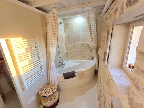 un bagno con vasca, doccia e lavandino di Les Terrasses de Flaugnac a Flaugnac