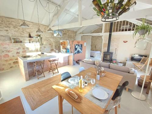 ein Wohnzimmer mit einem Holztisch und einer Küche in der Unterkunft Les Terrasses de Flaugnac in Flaugnac