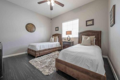 a bedroom with two beds and a ceiling fan at No Ho yellow door bungalow in Tampa