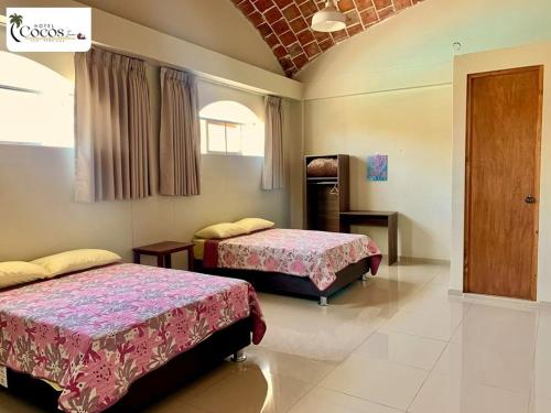 una habitación con dos camas en una habitación en Hotel Cocos Inn, en Ica
