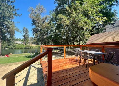 una terrazza in legno con tavolo e sedie. di Deluxe Cabin 1 - Rogue River Resort a Grants Pass