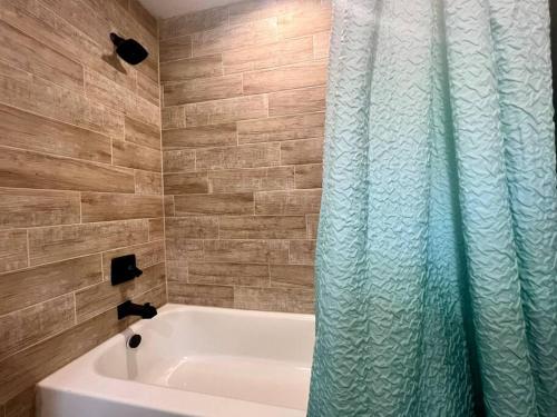 a bathroom with a tub and a shower curtain at Deluxe Cabin 1 - Rogue River Resort in Grants Pass