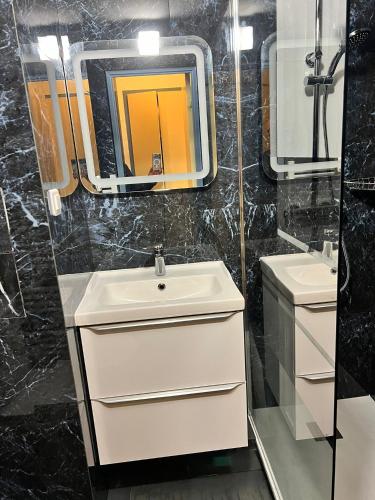 une salle de bain avec un lavabo et un miroir dans l'établissement Magnifique T2 Climatisation - Grande Terrasse, Piscine et apercu Mer, à Cannes