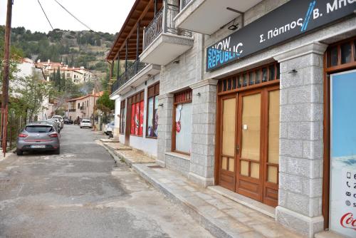 a street with a car parked in front of a building at Alkinoe Suite Arachova in Arachova