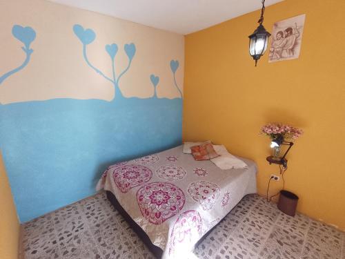 1 dormitorio con 1 cama con flores pintadas en la pared en Cuartos amueblados con servicios incluidos en Chapulco