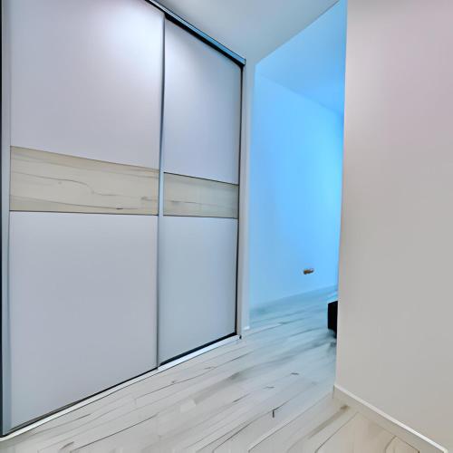 um quarto vazio com paredes de vidro e pisos de madeira em New cool stylish apartment em Bratislava