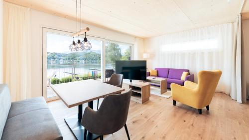 a living room with a table and chairs and a couch at Seewirt Apartments in Klopein am Klopeiner See