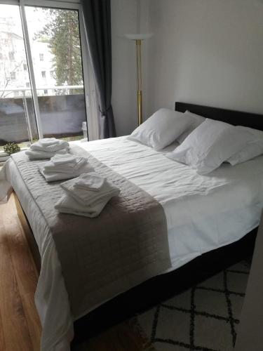 une chambre avec un lit avec des draps blancs et une fenêtre dans l'établissement Paris-Daumesnil - Grand 2 pieces 4 etoiles de charme sur jardin - 61m2, pour 4p - Large 4 star charming 1 BR apt for 4 with AC, à Paris
