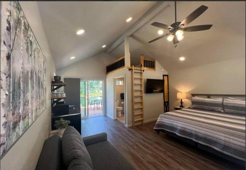 a bedroom with a bed and a ceiling fan at Loft Cabin 2 - Rogue River Resort in Grants Pass