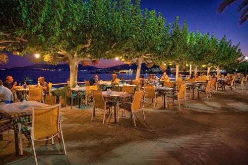 a row of tables and chairs with people sitting at them at Samanthas LUXURY APARTMENT in Haraki