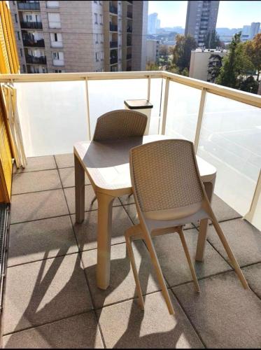 einen Tisch und einen Stuhl auf dem Balkon in der Unterkunft Nanterre home in Nanterre