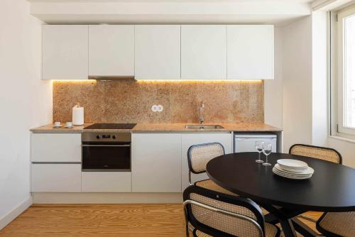 een keuken met een zwarte tafel en een keuken met witte kasten bij Apartamento Jardim Azul Downtown Apartments in Coimbra
