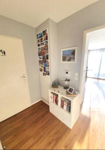 ein Zimmer mit einem weißen Schrank mit Büchern darauf in der Unterkunft Nanterre home in Nanterre