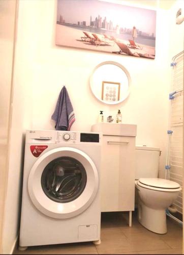 ein Badezimmer mit einer Waschmaschine und einem WC in der Unterkunft Nanterre home in Nanterre