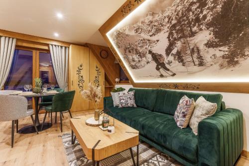 a living room with a green couch and a table at Apartamenty Mrowca in Ząb