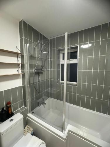 ein Bad mit einer Badewanne und einem WC in der Unterkunft Modern 1 Bedroom House in Biggleswade in Biggleswade