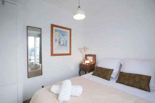 une chambre blanche avec un lit et un miroir dans l'établissement Heavenly & Cozy Parisian Flat - Place Voltaire, à Paris