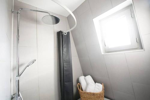 La salle de bains est pourvue d'une douche et d'un panier de serviettes. dans l'établissement Heavenly & Cozy Parisian Flat - Place Voltaire, à Paris