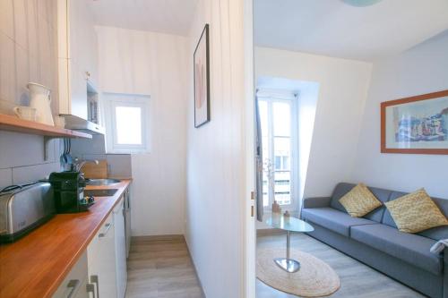 Il comprend une cuisine et un salon avec un canapé bleu. dans l'établissement Heavenly & Cozy Parisian Flat - Place Voltaire, à Paris