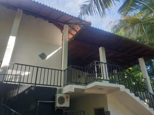 a house with a staircase leading up to a balcony at Nature guesthous in Midigama