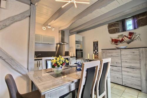 une cuisine avec une grande table et des chaises en bois dans l'établissement Le petit moulin kersigalec, à Canihuel