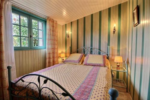 a bedroom with a bed and a window at Le petit moulin kersigalec in Canihuel