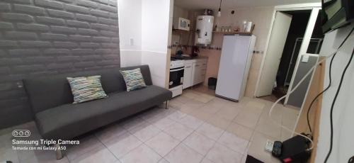 uma sala de estar com um sofá e uma cozinha em Huilliches NQN em Neuquén