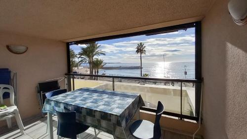 Cette chambre dispose d'une table et d'une fenêtre avec vue sur l'océan. dans l'établissement Les terrasses, à Cannes