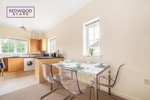 a kitchen with a table and chairs in it at 2 Bedroom Apartment, Business & Contractors, FREE Parking & Netflix By REDWOOD STAYS in Basingstoke