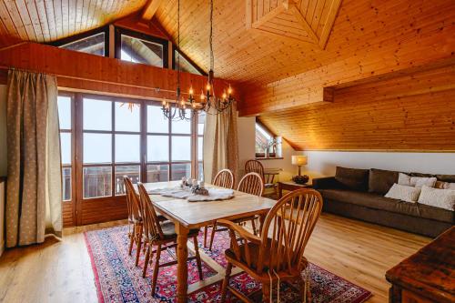 a dining room with a table and chairs and a couch at Landhaus BERGSEE in Bodensdorf