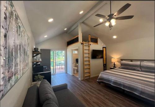 a bedroom with a bed and a ceiling fan at Loft Cabin 3 - Rogue River Resort in Grants Pass