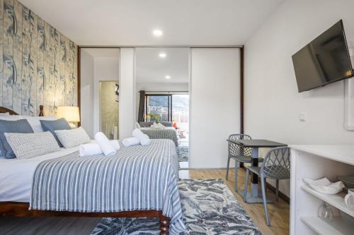a hotel room with a bed and a tv at White Rabbit I by Homie in Calheta
