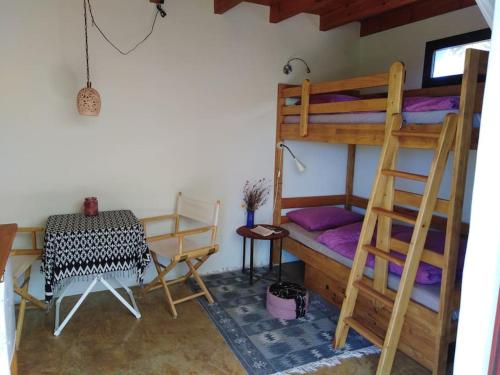 a room with two bunk beds and a table and a desk at Finca Caboquitos in Garafía