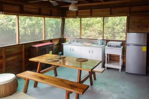 a kitchen with a wooden table in a cabin at Galapagos Chalet-Buda Chalet in Puerto Ayora