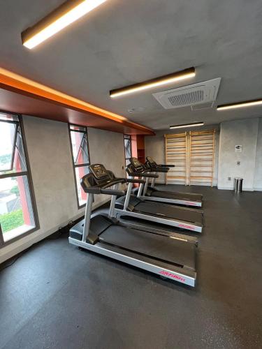 a gym with several treadmills in a room with windows at Apartamentos em frente ao Allianz Parque in Sao Paulo