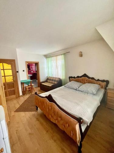 a bedroom with a large bed and a couch at Willa Maria in Kościelisko