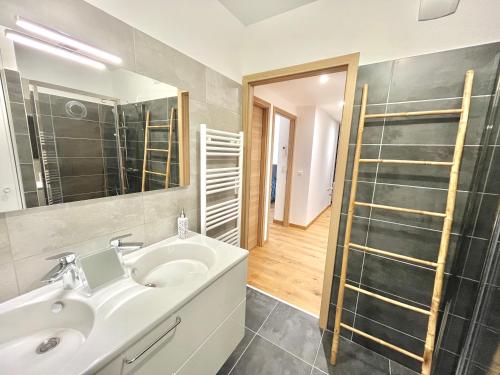 une salle de bain avec un lavabo, un miroir et une douche dans l'établissement Les terrasses de Toretta, à Ajaccio