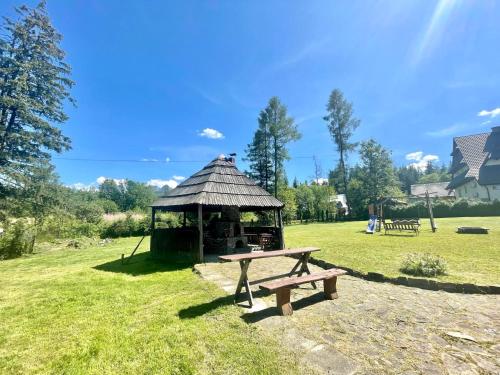 a picnic table and a gazebo in a field at Willa Maria in Kościelisko