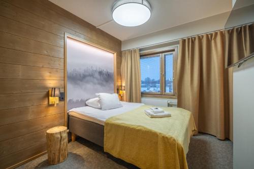 a bedroom with a bed and a large window at Kultahippu Hotel & Apartments in Ivalo