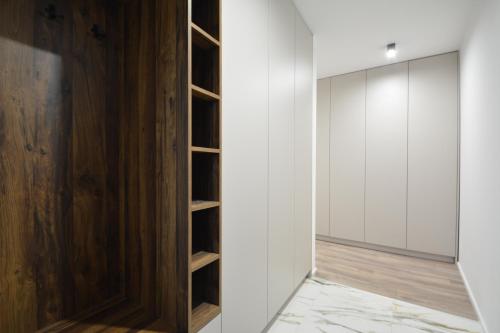 Zimmer mit weißen Wänden und einem Holzschrank in der Unterkunft Project IK luxury apartments in Seredʼ