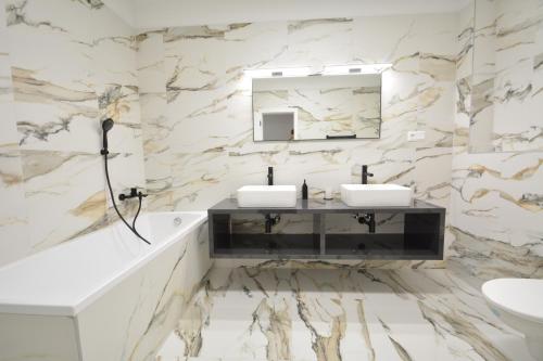 a bathroom with two sinks and a mirror at Project IK luxury apartments in Seredʼ
