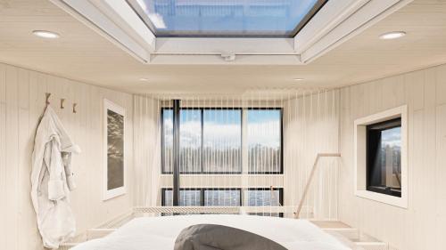 una camera da letto con lucernario, letto e finestra di BoraVilla - La brume - Cantons-de-l'Est a Bury