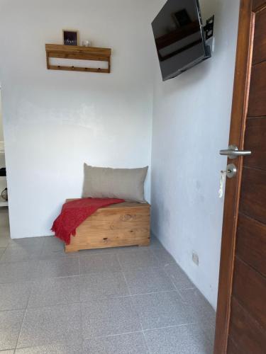 a room with a bench with a pillow and a tv at Habitación para 2 personas in Valeria del Mar