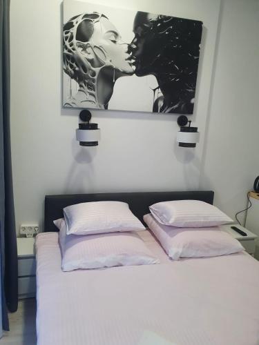 a bed with a picture of a couple kissing at Comfort Stay, EV, Parking in Bolesławiec