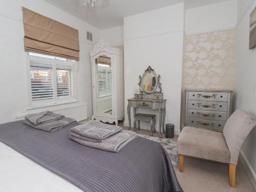 Schlafzimmer mit einem Bett, einer Kommode und einem Spiegel in der Unterkunft 202 Salisbury Terrace in York
