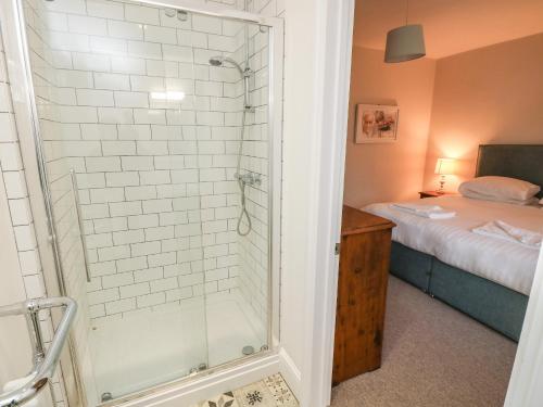 a bathroom with a shower and a bed at Appuldurcombe Farmhouse in Ventnor